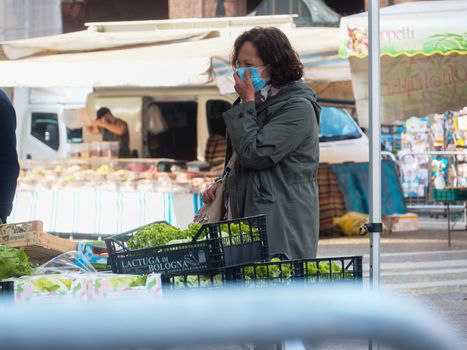 Cremona, Lombardy, Italy - 16 th may 2020 - People grocery shopping socially distance d in local biologic open air  food market wearing protection facial mask to prevent against contagion of coronavirus infection disease