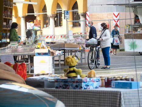 Cremona, Lombardy, Italy - 16 th may 2020 - People grocery shopping socially distance d in local biologic open air  food market wearing protection facial mask to prevent against contagion of coronavirus infection disease