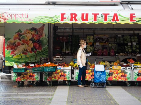 Cremona, Lombardy, Italy - 16 th may 2020 - People grocery shopping socially distance d in local biologic open air  food market wearing protection facial mask to prevent against contagion of coronavirus infection disease