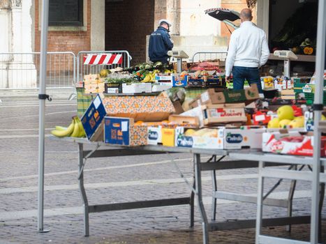 Cremona, Lombardy, Italy - 16 th may 2020 - People grocery shopping socially distance d in local biologic open air  food market wearing protection facial mask to prevent against contagion of coronavirus infection disease