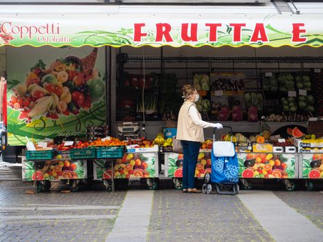 Cremona, Lombardy, Italy - 16 th may 2020 - People grocery shopping socially distance d in local biologic open air  food market wearing protection facial mask to prevent against contagion of coronavirus infection disease