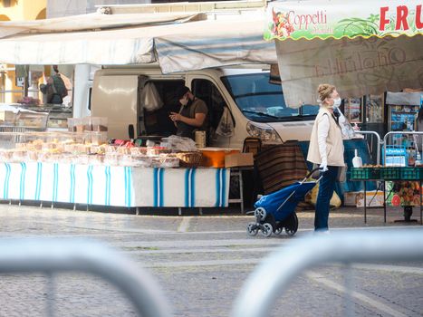 Cremona, Lombardy, Italy - 16 th may 2020 - People grocery shopping socially distance d in local biologic open air  food market wearing protection facial mask to prevent against contagion of coronavirus infection disease