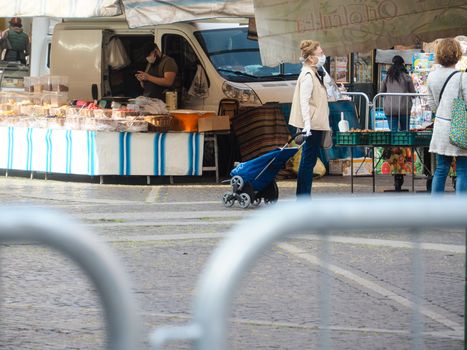 Cremona, Lombardy, Italy - 16 th may 2020 - People grocery shopping socially distance d in local biologic open air  food market wearing protection facial mask to prevent against contagion of coronavirus infection disease