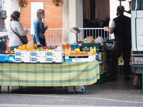 Cremona, Lombardy, Italy - 16 th may 2020 - People grocery shopping socially distance d in local biologic open air  food market wearing protection facial mask to prevent against contagion of coronavirus infection disease