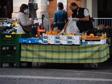 Cremona, Lombardy, Italy - 16 th may 2020 - People grocery shopping socially distance d in local biologic open air  food market wearing protection facial mask to prevent against contagion of coronavirus infection disease