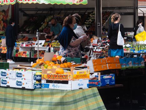 Cremona, Lombardy, Italy - 16 th may 2020 - People grocery shopping socially distance d in local biologic open air  food market wearing protection facial mask to prevent against contagion of coronavirus infection disease