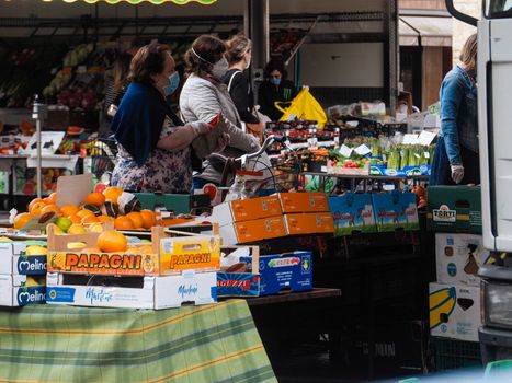 Cremona, Lombardy, Italy - 16 th may 2020 - People grocery shopping socially distance d in local biologic open air  food market wearing protection facial mask to prevent against contagion of coronavirus infection disease