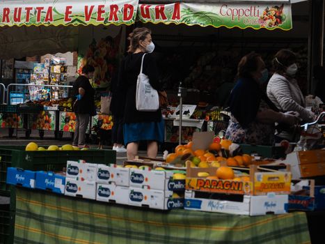 Cremona, Lombardy, Italy - 16 th may 2020 - People grocery shopping socially distance d in local biologic open air  food market wearing protection facial mask to prevent against contagion of coronavirus infection disease