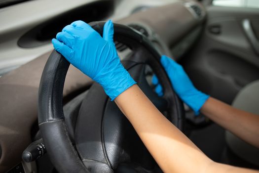 Woman puts on protective rubber gloves and driving a car