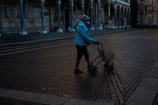 Cremona, Lombardy, Italy - April 30 th - May 1st 2020 - people biking walking dog walking in the center during covid 19  lockdown and economic crisis in Lombardy affected region.