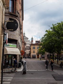 Cremona, Lombardy, Italy - April 30 th - May 1st 2020 - people biking walking dog walking in the center during covid 19  lockdown and economic crisis in Lombardy affected region.