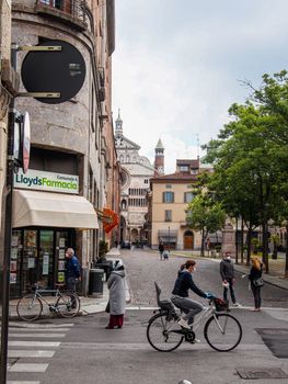 Cremona, Lombardy, Italy - April 30 th - May 1st 2020 - people biking walking dog walking in the center during covid 19  lockdown and economic crisis in Lombardy affected region.