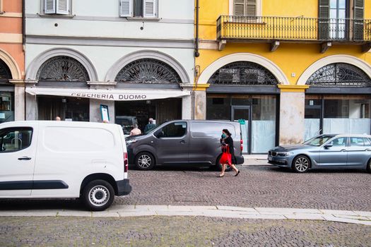 Cremona, Lombardy, Italy - April 30 th - May 1st 2020 - people biking walking dog walking in the center during covid 19  lockdown and economic crisis in Lombardy affected region.