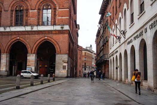 Cremona, Lombardy, Italy - April 30 th - May 1st 2020 - people biking walking dog walking in the center during covid 19  lockdown and economic crisis in Lombardy affected region.