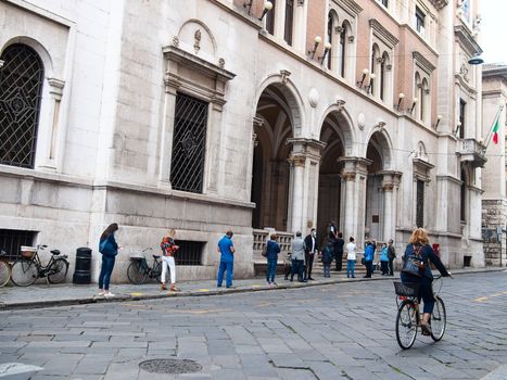 Cremona, Lombardy, Italy - May  5 6 7  2020 - man or woman walking or biking in deserted downtown  during covid outbreak lockdown phase 2