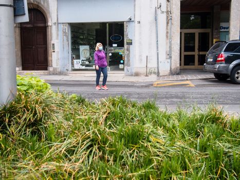 Cremona, Lombardy, Italy - May  5 6 7  2020 - man or woman walking or biking in deserted downtown  during covid outbreak lockdown phase 2