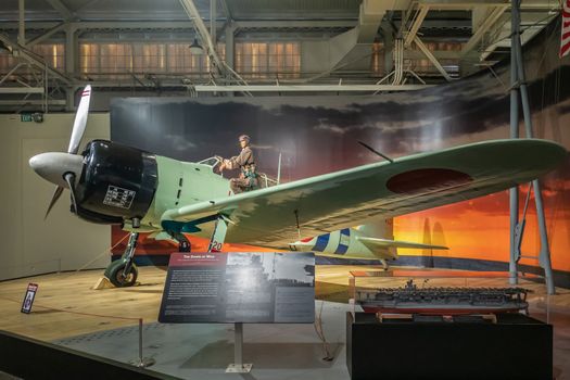 Oahu, Hawaii, USA. - January 10, 2020: Pearl Harbor Aviation Museum. Japanese airplane called zero with pilot stepping into his aircraft, inside hangar.