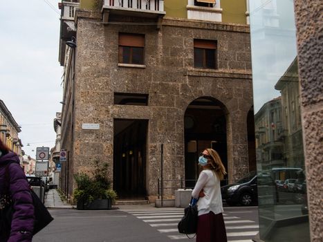 Cremona, Lombardy, Italy - May  5 6 7  2020 - man or woman walking or biking in deserted downtown  during covid outbreak lockdown phase 2