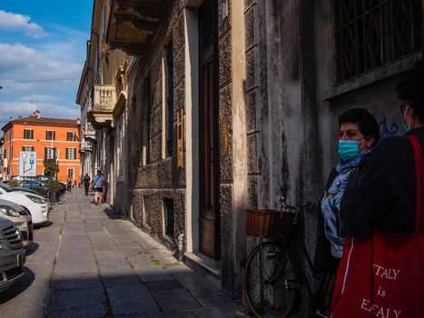 Cremona, Lombardy, Italy - May  5 6 7  2020 - man or woman walking or biking in deserted downtown  during covid outbreak lockdown phase 2