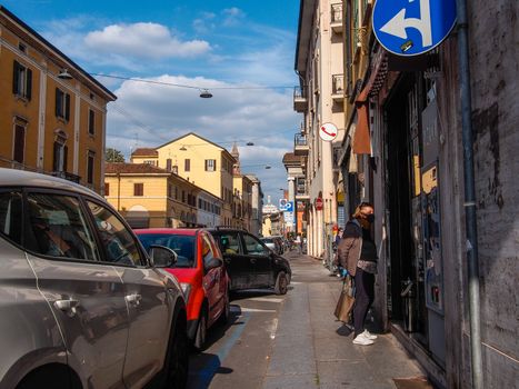 Cremona, Lombardy, Italy - May  5 6 7  2020 - man or woman walking or biking in deserted downtown  during covid outbreak lockdown phase 2