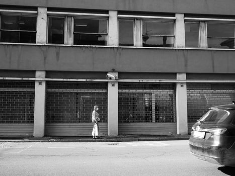 Cremona, Lombardy, Italy - May  5 6 7  2020 - man or woman walking or biking in deserted downtown  during covid outbreak lockdown phase 2