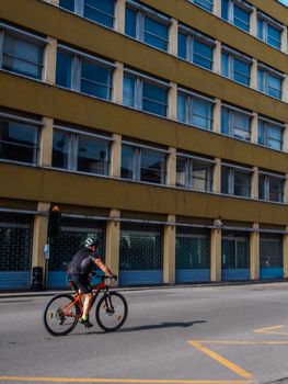 Cremona, Lombardy, Italy - May  5 6 7  2020 - man or woman walking or biking in deserted downtown  during covid outbreak lockdown phase 2