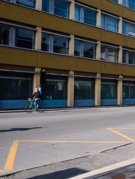Cremona, Lombardy, Italy - May  5 6 7  2020 - man or woman walking or biking in deserted downtown  during covid outbreak lockdown phase 2