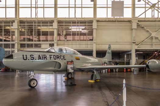 Oahu, Hawaii, USA. - January 10, 2020: Pearl Harbor Aviation Museum. The light gray fabulous Lockheed T-bird or T-33 in hangar. Beige wall. Natural light through windows.