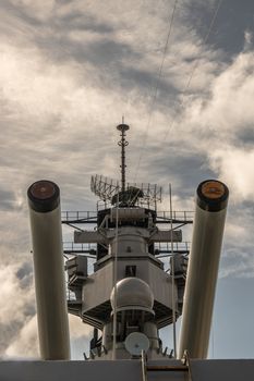 Oahu, Hawaii, USA. - January 10, 2020: Pearl Harbor. Closeup of 2 heavy guns with tower in between of USS Missouri Battle Ship under white-blue cloudscape.