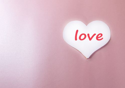 White background with paper heart and the words LOVE pink background heart, love, holiday greeting card, a minimum of creative idea of a holiday Valentine's day, space for copy.