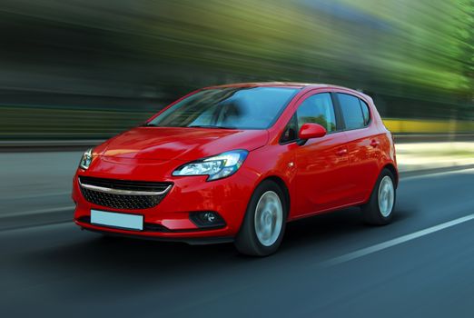 A panning shot of a speeding red car