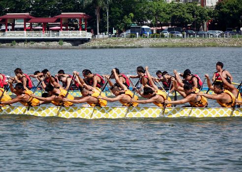 KAOHSIUNG, TAIWAN -- JUNE 1, 2014: Two unidentified teams take part in the 2014 Dragon Boat Event on the Lotus Lake.