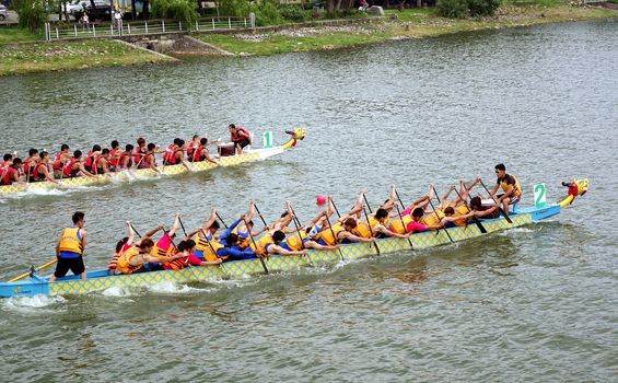 KAOHSIUNG, TAIWAN - MAY 25, 2014: Two unidentified teams compete in the 2014 Dragon Boat Races on the Lotus Lake.
