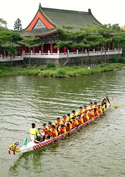 KAOHSIUNG, TAIWAN -- MAY 25, 2014: An unidentified team approaches the starting line for the 2014 Dragon Boat Races on the Lotus Lake.
