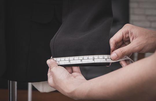 Clothing stylist is measuring jacket sleeve