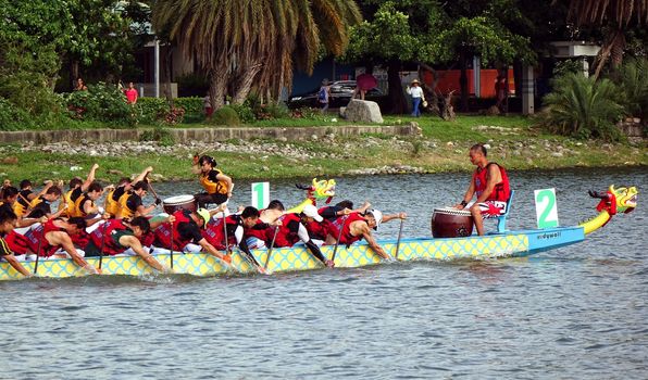 KAOHSIUNG, TAIWAN - MAY 25, 2014: Two unidentified teams compete in the 2014 Dragon Boat Races on the Lotus Lake.