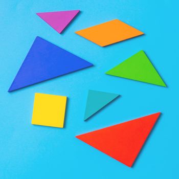 Colorful wooden tangram  puzzle toy on blue