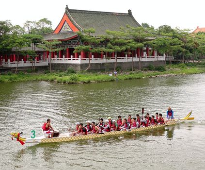 KAOHSIUNG, TAIWAN -- MAY 25, 2014: The China Steel Corporation team approaches the starting line for the 2014 Dragon Boat Races on the Lotus Lake.