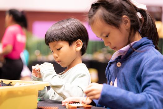 Asian girl and boy is playing with educational toy