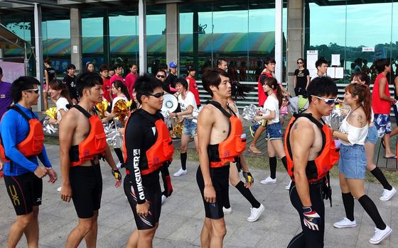 KAOHSIUNG, TAIWAN -- MAY 25, 2014: Pretty cheerleaders spur on a team of athletes as they get ready to take part in the 2014 Dragon Boat Races on the Lotus Lake.