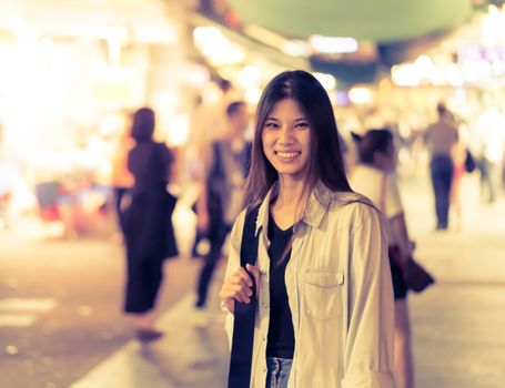 Cute Asian traveler girl in the night street of Hong Kong