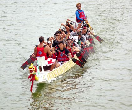 KAOHSIUNG, TAIWAN - MAY 25, 2014: A team from China Steel Corporation competes in the 2014 Dragon Boat Races on the Lotus Lake.