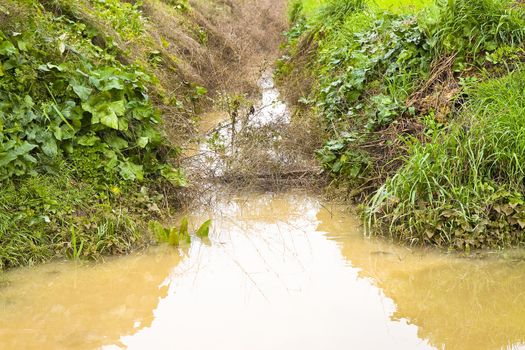 Full water ditch in a field after torrential rain