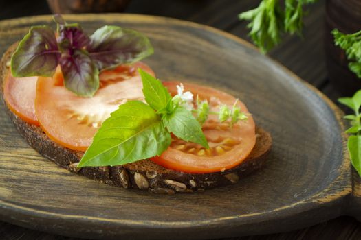 Bruschetta with tomatoes and basil on a dark wooden background. Close up