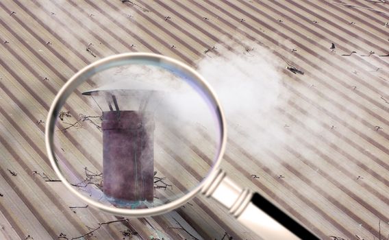 Metal chimney on copper roof with smoke - concept image seen through a magnifying glass.
