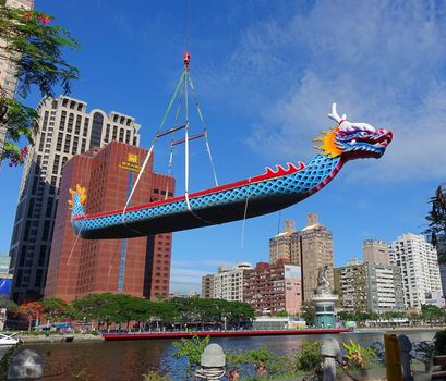 KAOHSIUNG, TAIWAN -- MAY 27, 2016: A crane lowers a dragon boat into the Love River in preparation for the upcoming Dragon Boat Festival.