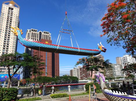 KAOHSIUNG, TAIWAN -- MAY 27, 2016: A crane lowers a dragon boat into the Love River in preparation for the upcoming Dragon Boat Festival.