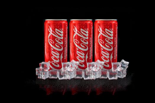 Kuala Lumpur, Malaysia - March 5, 2020 : Cola cola drink stacking on black background. Coca Cola is competitor of Pepsi drink. Copy Space