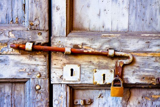 Front view of a closed old wooden door with rusty metal bolt - safety concept image.