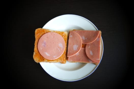 slice bread with pork ham on white dish